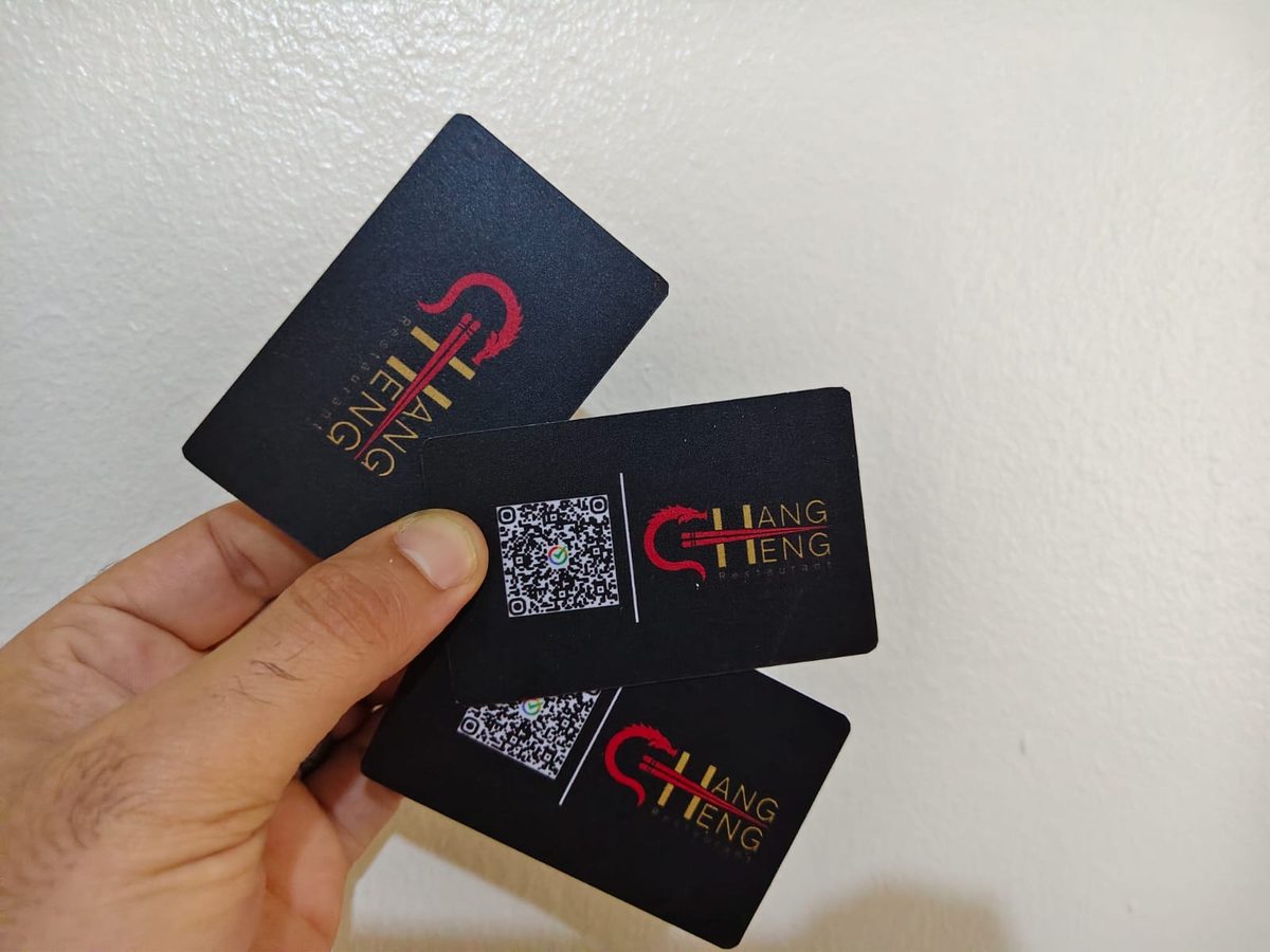 شخص يحمل بطاقات أعمال رقمية NFC سوداء أنيقة