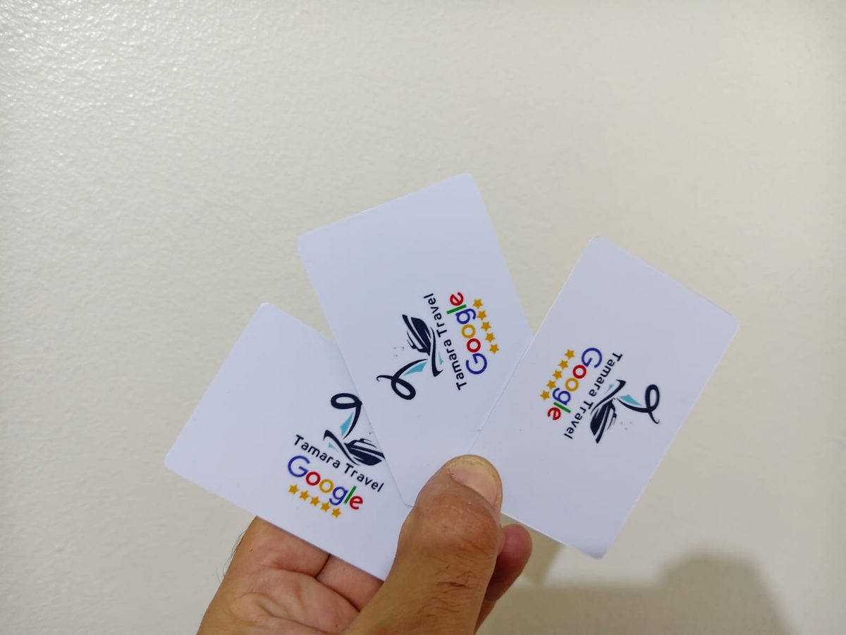 شخص يحمل بطاقات أعمال رقمية NFC بيضاء بتصميمات مختلفة